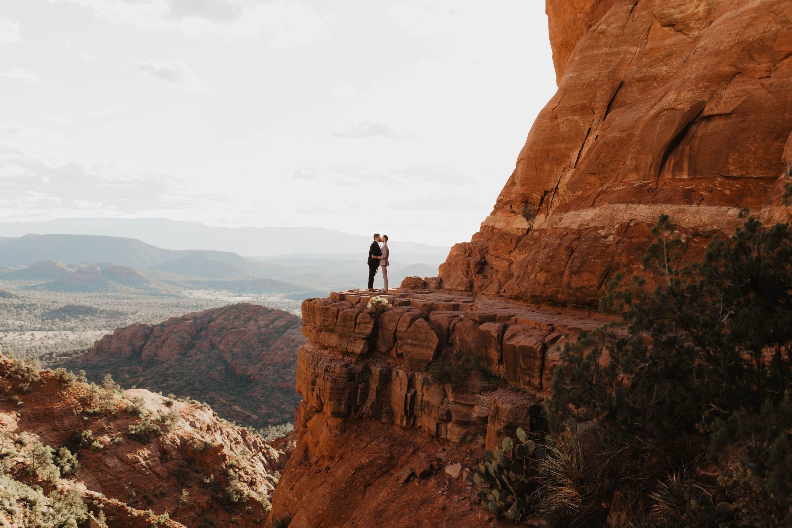 Same sex gay couple standing on the edge of an Arizona cliff during a Sedona Engagement session