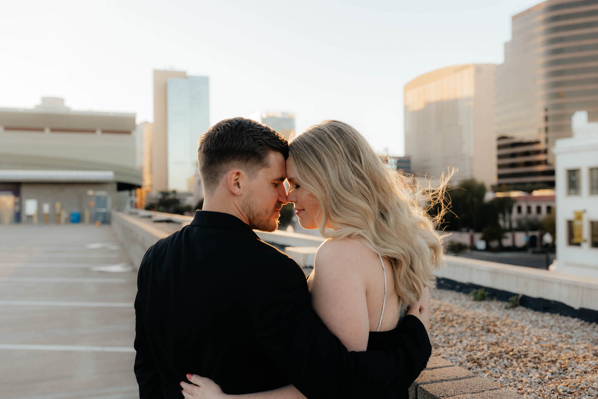 bride and groom to be look lovingly into each others eyes with the backdrop of downtown phoenix in this vintage inspired engagement photoshoot